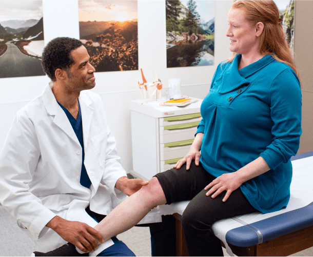 Optum OR doctor examining a patient's knee during a medical consultation