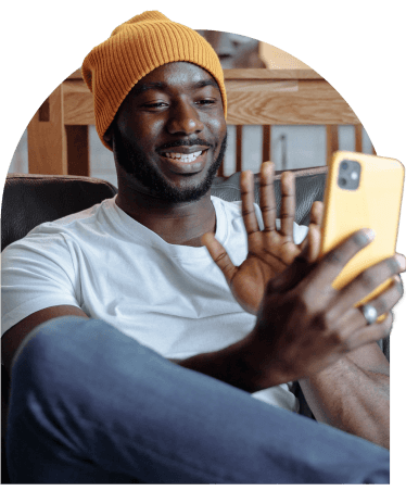 Smiling man waving during a video call on his smartphone